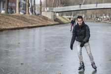 910706 Afbeelding van een schaatser op een bevroren Stadsbuitengracht ter hoogte van de Catharijnesingel te Utrecht, ...